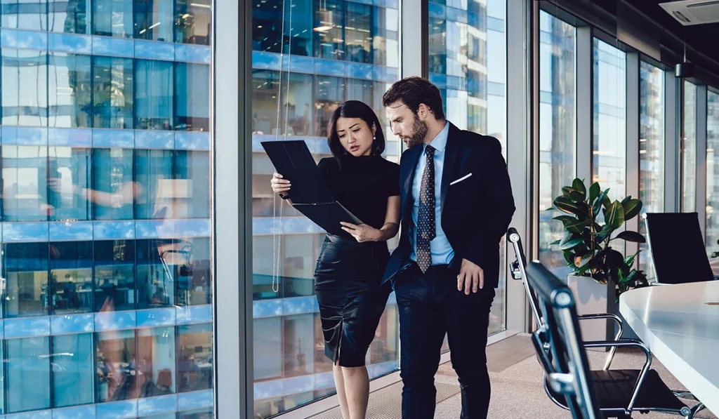 Our shareholders - Asian women and Caucasian man discussing over an ipad